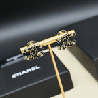 Gold-tone chain earrings on display stand with stud backs visible