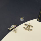 Gold-tone logo stud earrings with pink stones and faux pearls, close-up angle