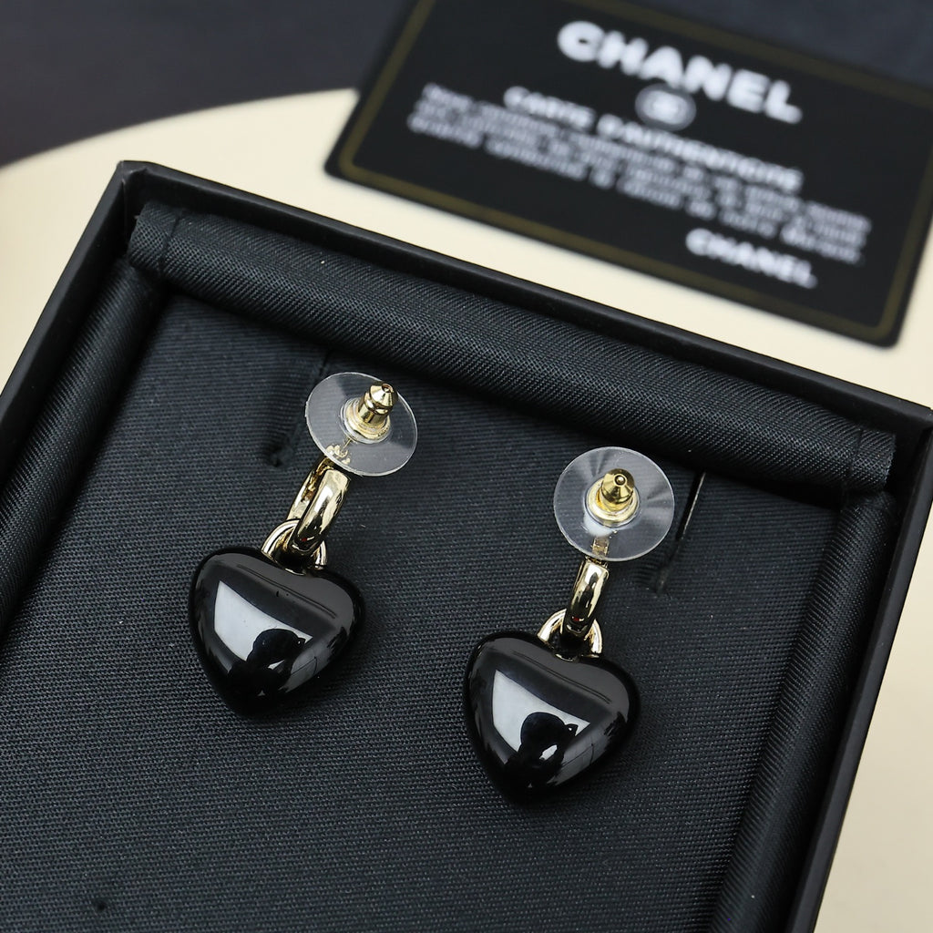 Chanel heart charm earrings in box, black resin heart drops with gold-tone CC logo.