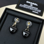 Chanel heart charm earrings in box, black resin heart drops with gold-tone CC logo.