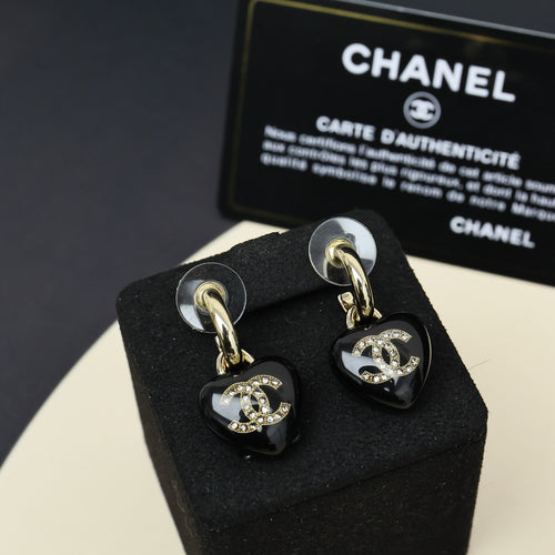 Chanel heart charm drop earrings, black resin with gold-tone CC logo and crystal accents.