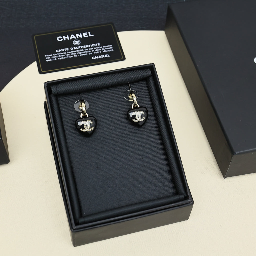 Chanel heart charm earrings set in black box, black resin heart drops with gold-tone CC.