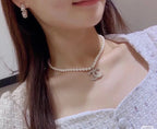 Pearl choker necklace with bow charm and matching hoop earrings on model.
