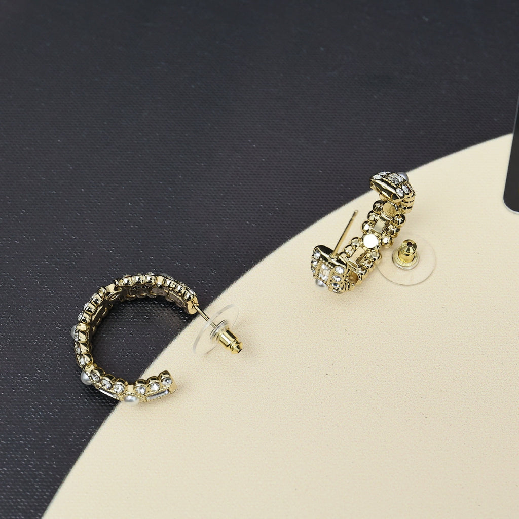 Gold-tone hoop earring and drop stud earring with pearl and rhinestone accents.
