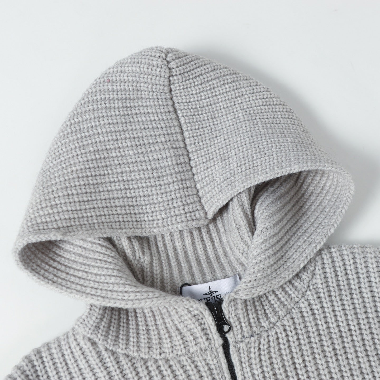 Light gray ribbed knit hoodie with hood, showing partial front zipper