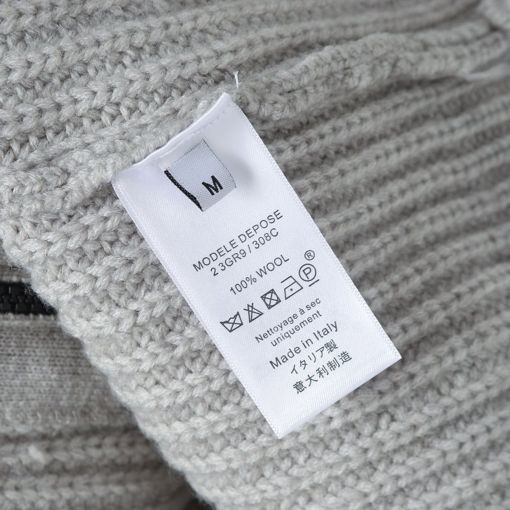 Stone Island knitwear care label on light gray ribbed fabric, size M