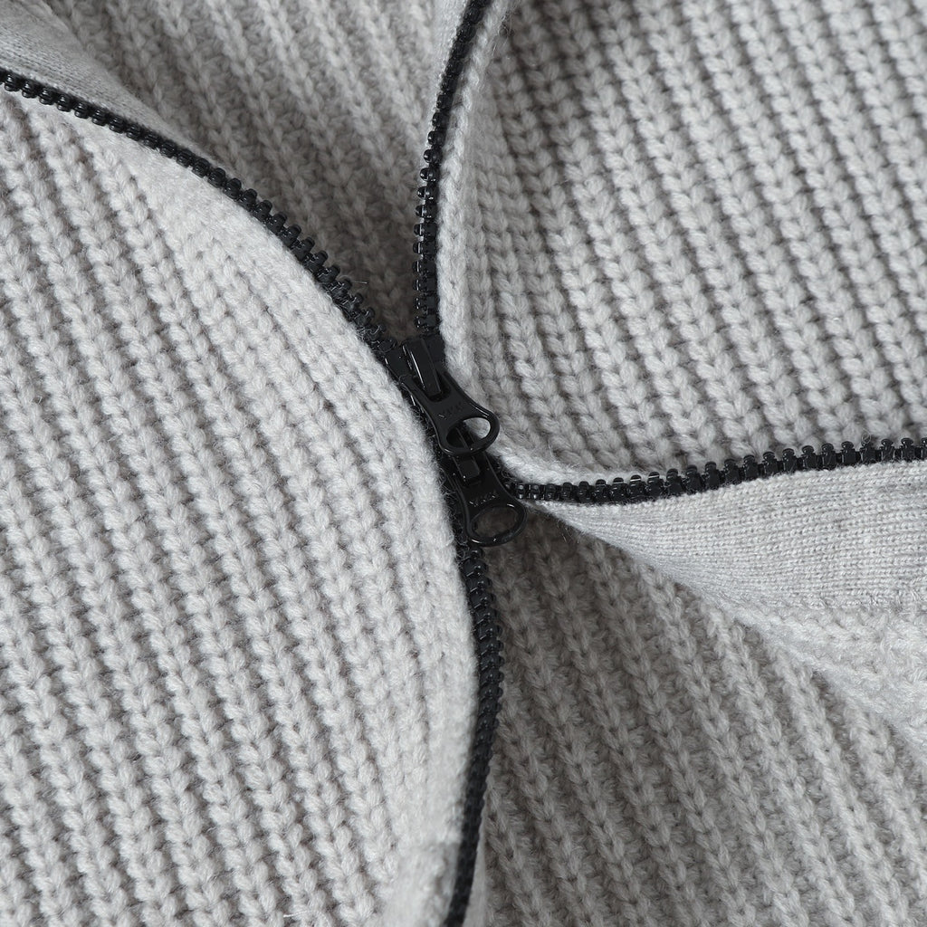 Close-up of light gray knit hoodie zipper track with black pull hardware
