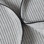 Close-up of light gray knit hoodie zipper track with black pull hardware