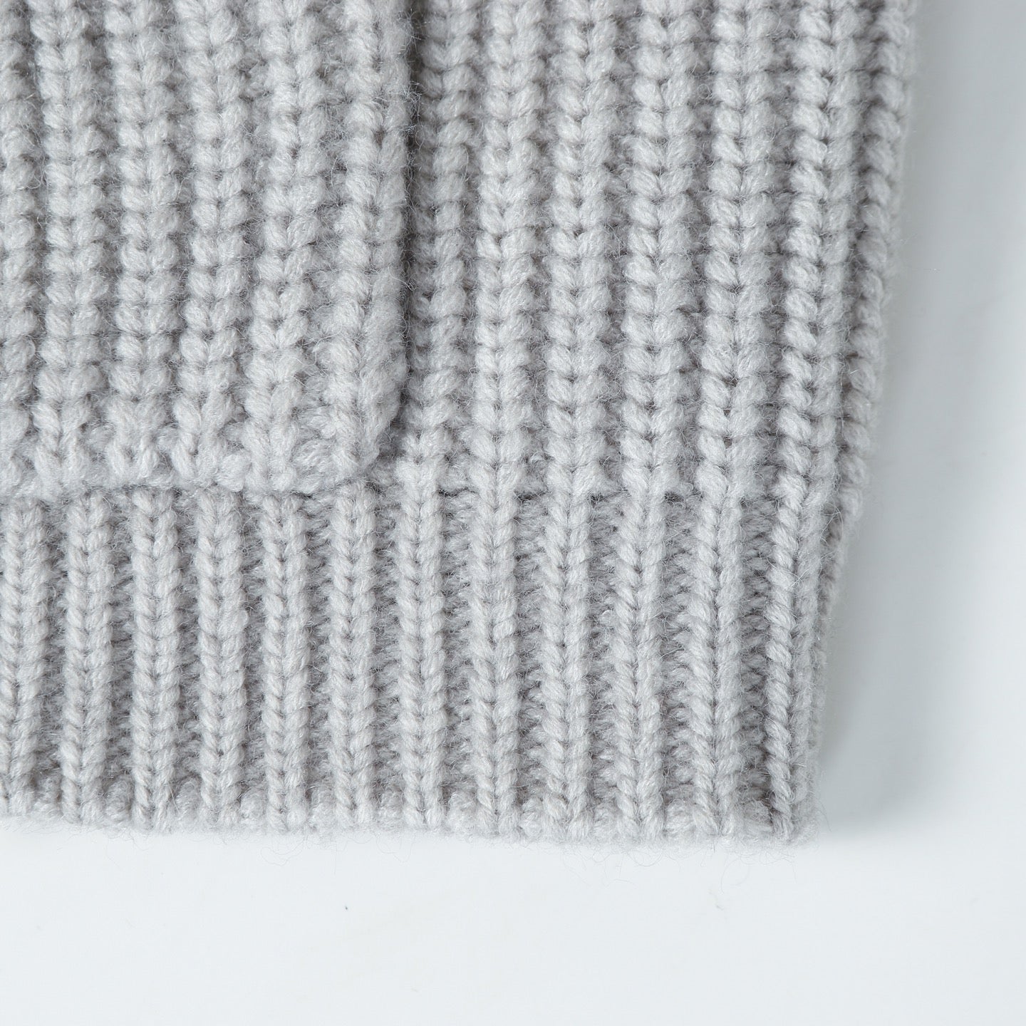 Light gray ribbed knit hoodie hem with vertical stitch texture