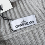Light gray knit hoodie label at neckline with black zipper pull