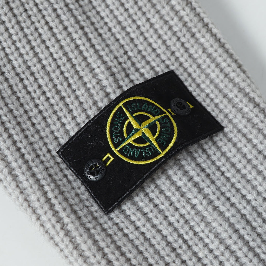 Stone Island knitwear brand patch on light gray knit fabric