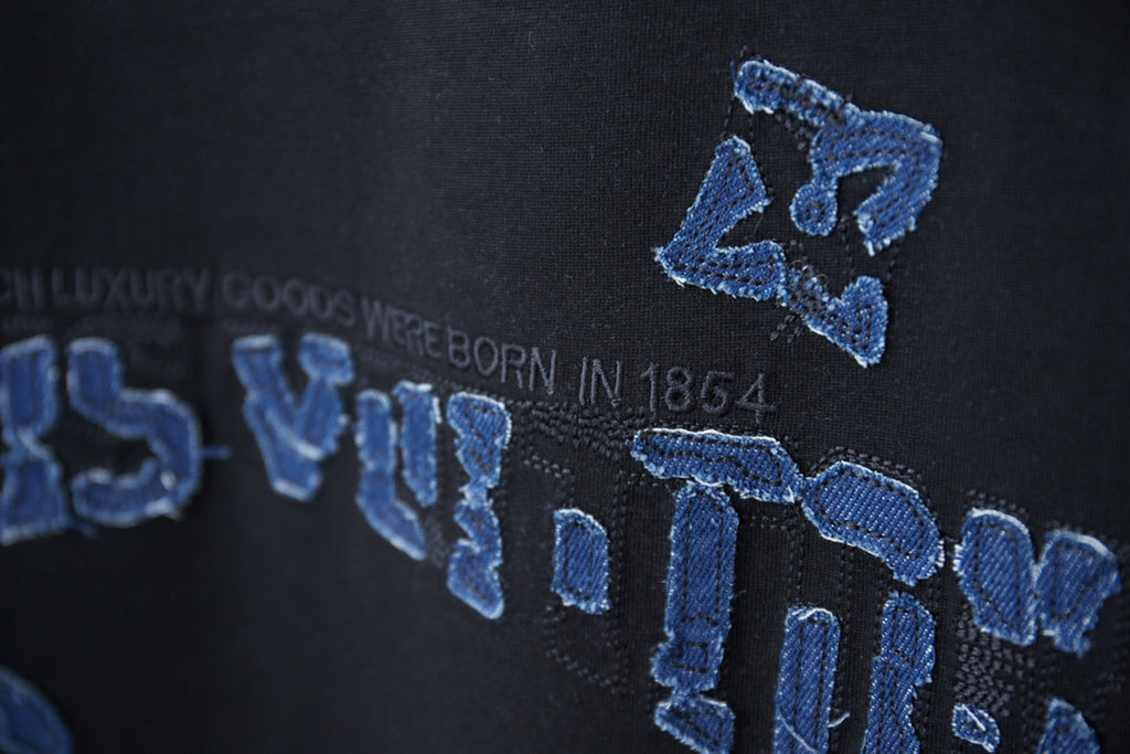 Louis Vuitton black T-shirt embroidery detail with blue LV logo graphic