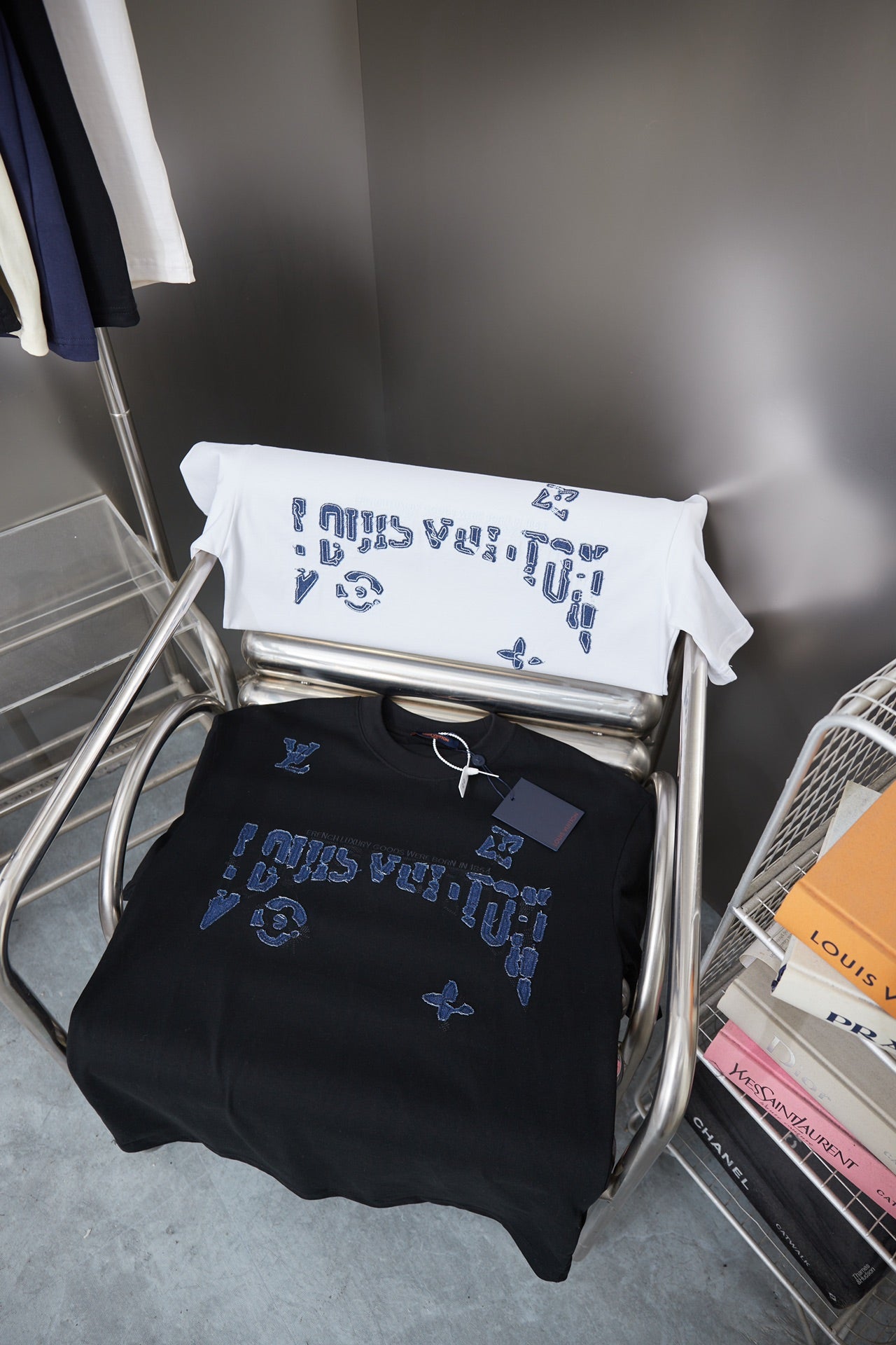 Louis Vuitton folded T-shirts on display: black and white with blue LV graphic
