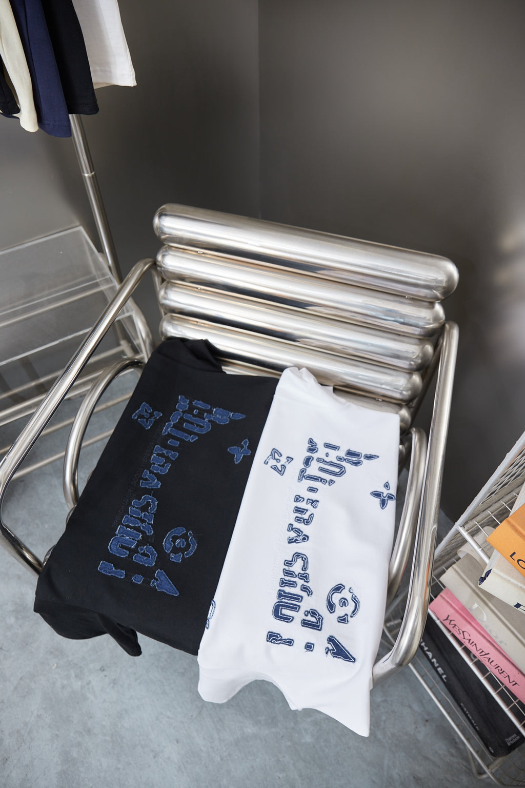 Louis Vuitton folded T-shirts on rack: black and white with blue LV logo print
