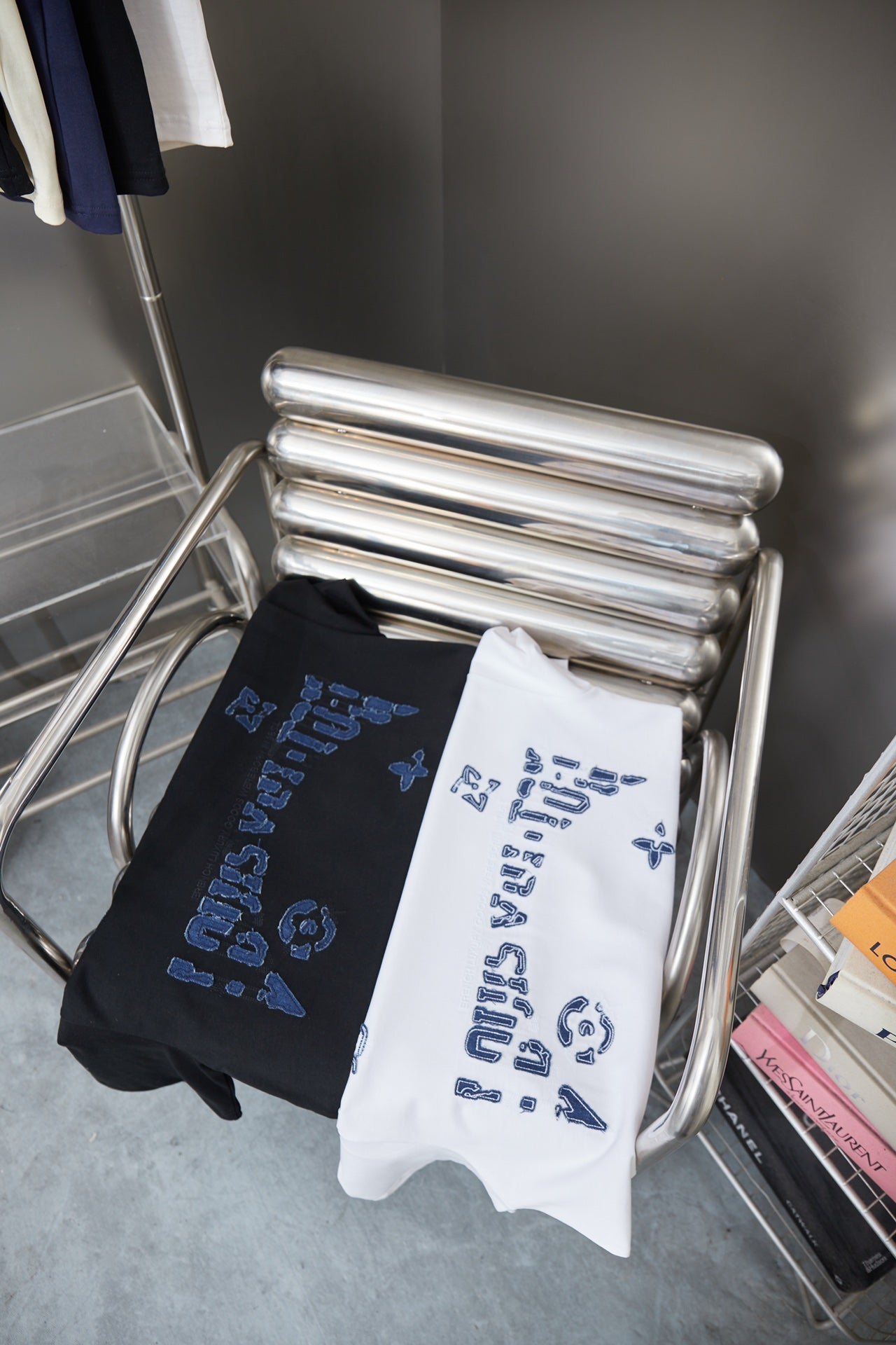 Louis Vuitton folded T-shirts on rack: black and white with blue LV logo print