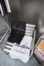 Black and white short-sleeve T-shirts folded on a rack with LV-style script graphics