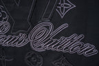 Black short-sleeve T-shirt close-up of embroidered LV-style script and monogram
