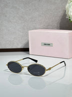 MiuMiu oval eyeglasses with gold-tone metal frame, black temple tips, black lenses