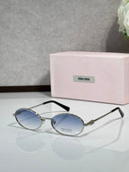 MiuMiu oval eyeglasses with gold-tone metal frame and black temple tips, dark blue lenses