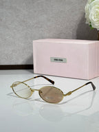 MiuMiu oval eyeglasses with gold-tone metal frame, tortoiseshell bridge, dark lenses