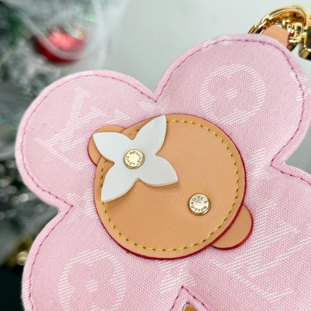 Louis Vuitton pink flower keychain close-up of beige center patch with white bow