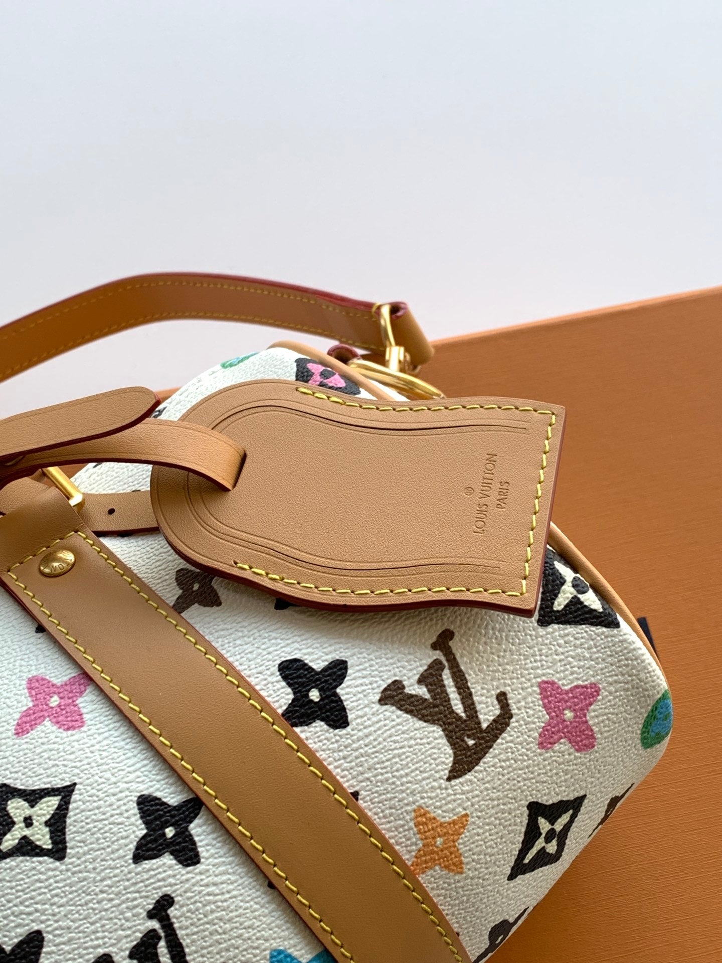 Louis Vuitton mini handbag front patch detail with tan leather trim and gold hardware