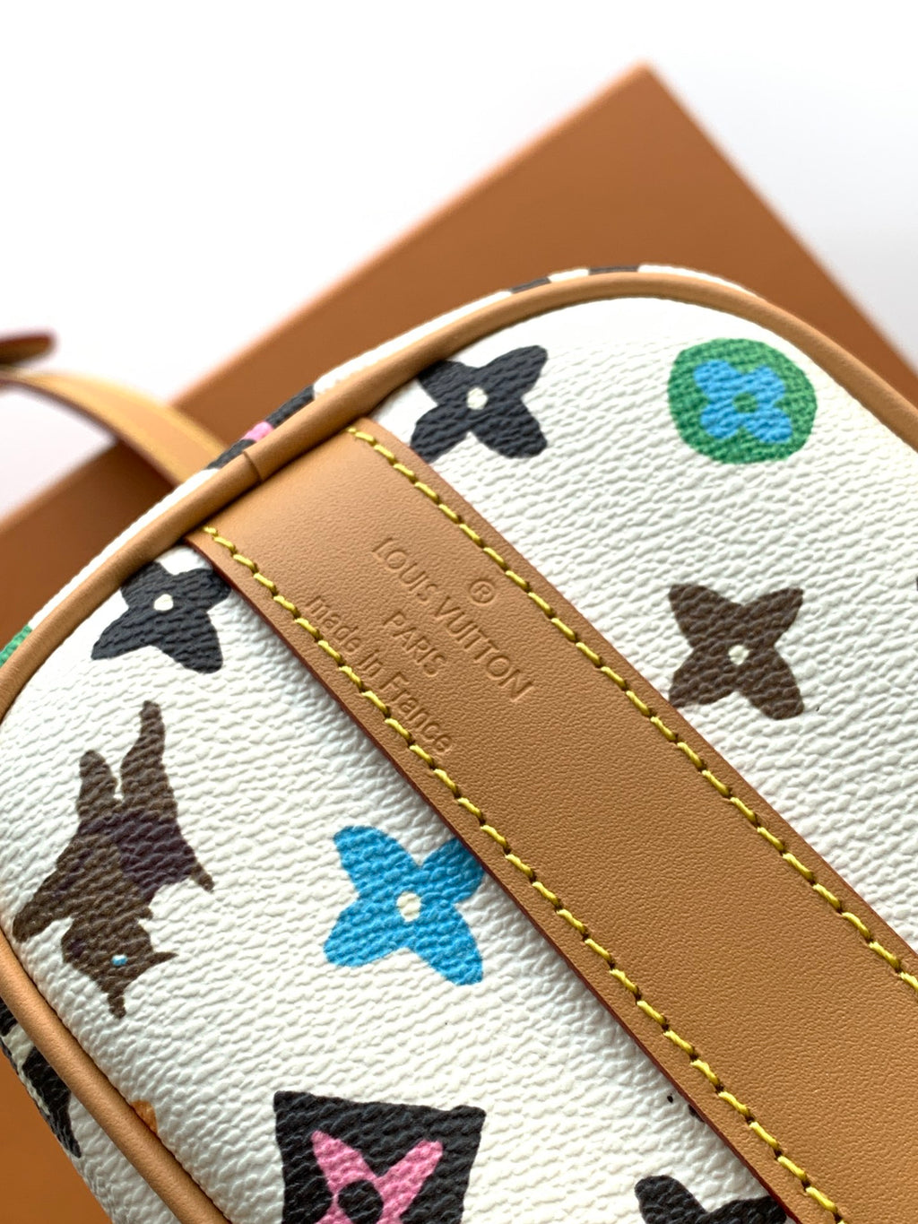 Louis Vuitton mini handbag close-up of logo embossing on tan leather trim