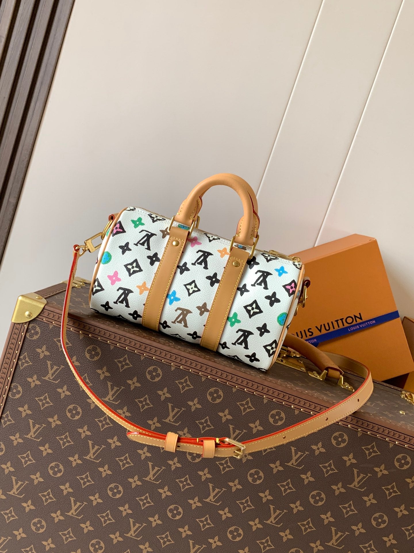 Louis Vuitton mini handbag with white monogram print and tan crossbody strap