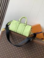 Louis Vuitton green leather handbag with front details and crossbody strap