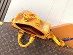 Louis Vuitton monogram bag with zip closure, yellow strap, and paw zipper pull