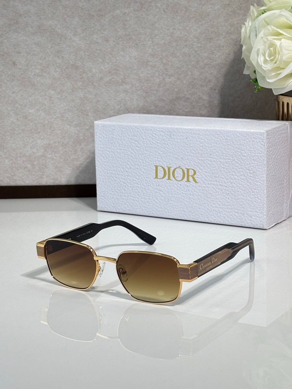 Sunglasses with gold frame and dark gray lenses, round cat-eye shape
