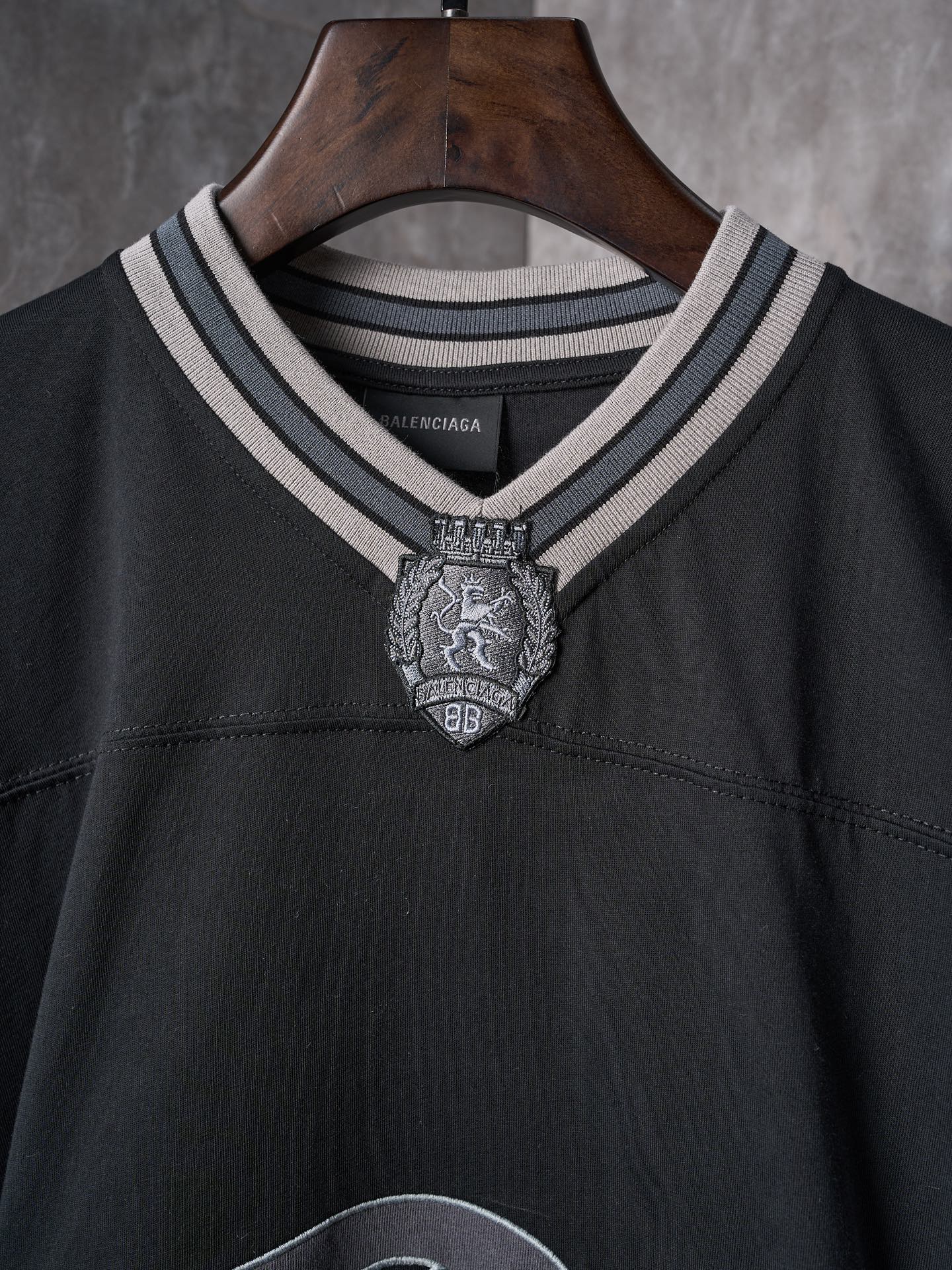 Balenciaga black T-shirt neckline with striped collar trim and crest emblem