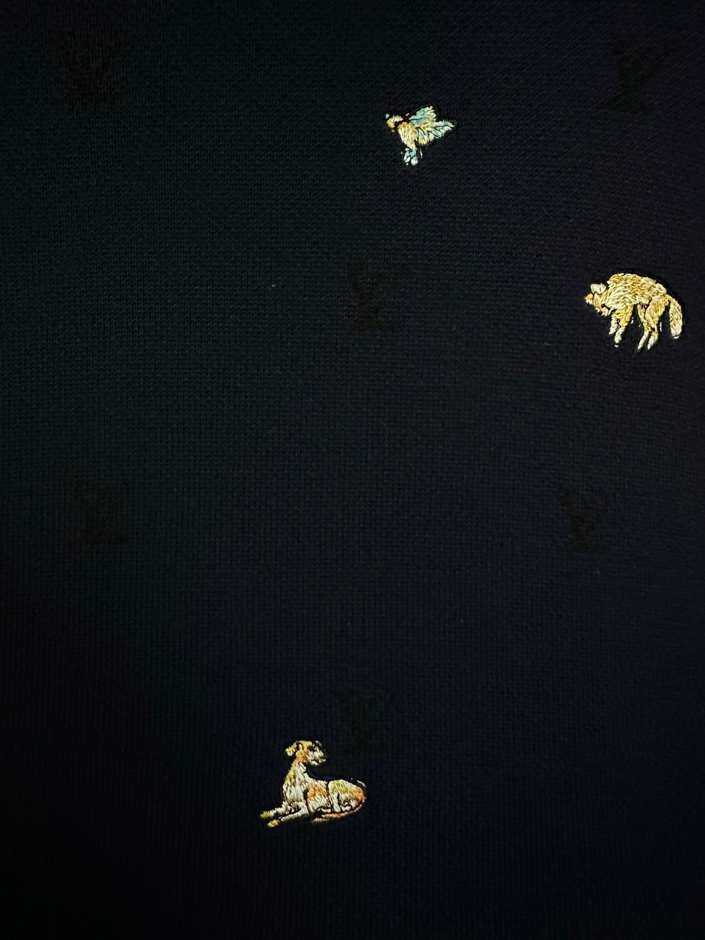 Dark navy sweater with small gold animal embroidery accents