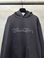 Black long-sleeve hoodie with rhinestone script logo, front close-up and kangaroo pocket