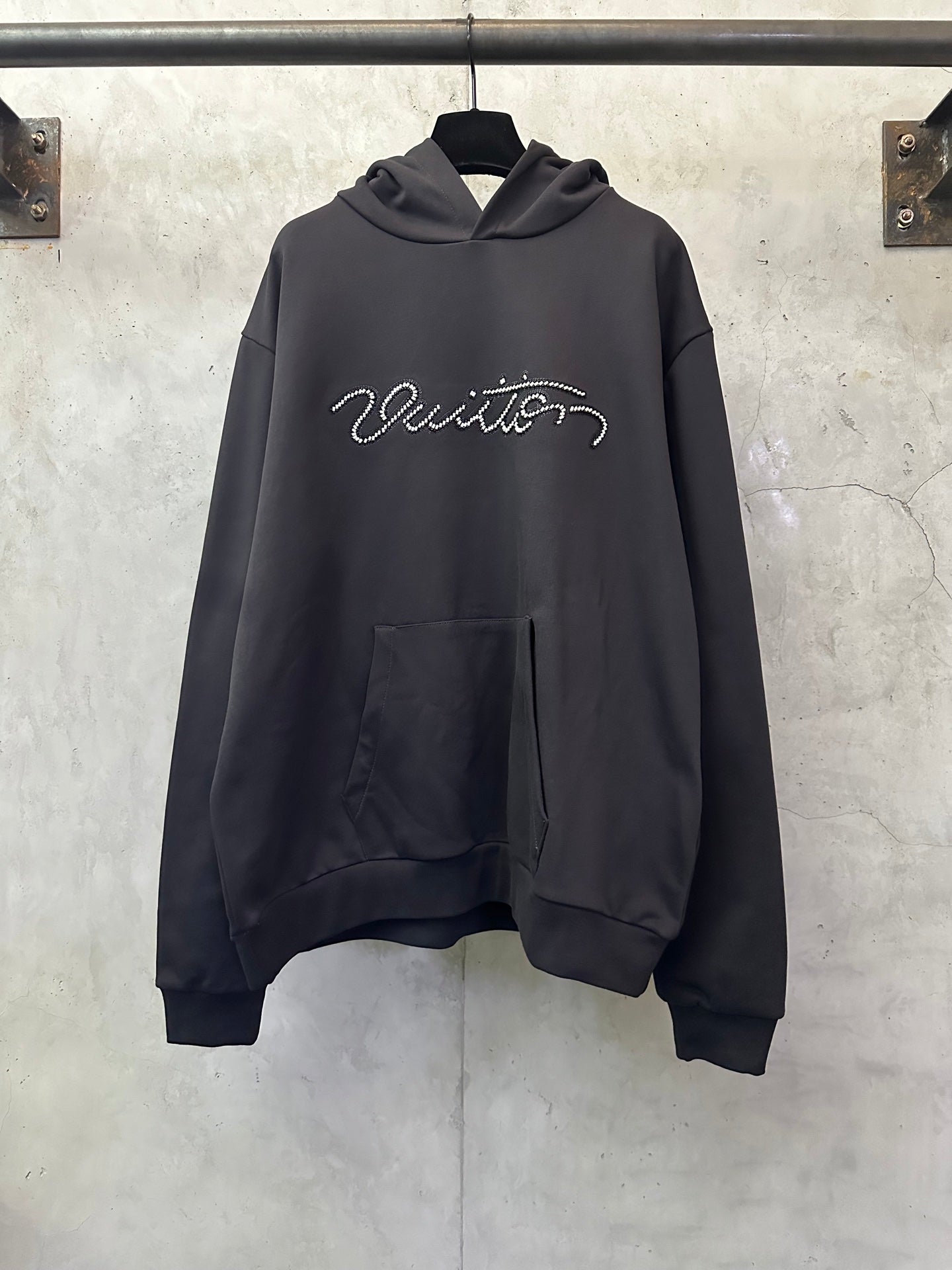 Black long-sleeve hoodie with rhinestone script logo and front kangaroo pocket