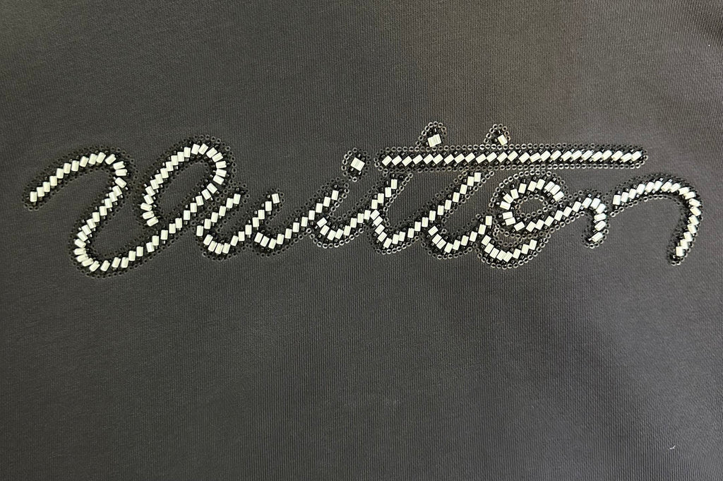 Rhinestone script logo on black long-sleeve hoodie front