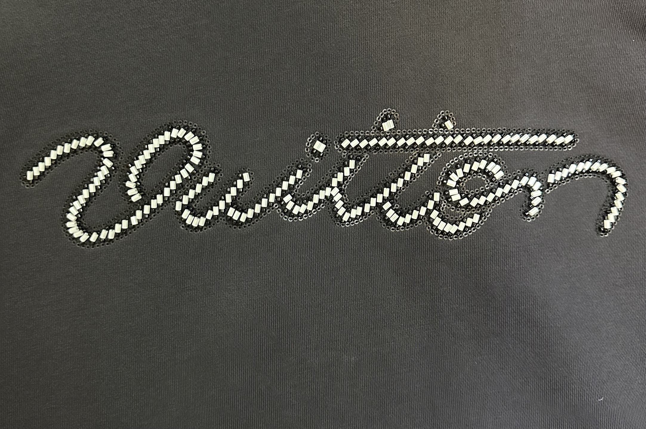 Rhinestone script logo on black long-sleeve hoodie front