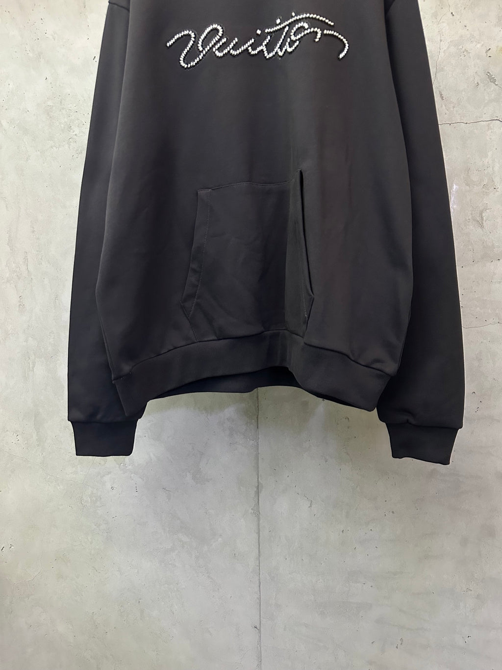 Black long-sleeve hoodie with rhinestone script logo and front kangaroo pocket