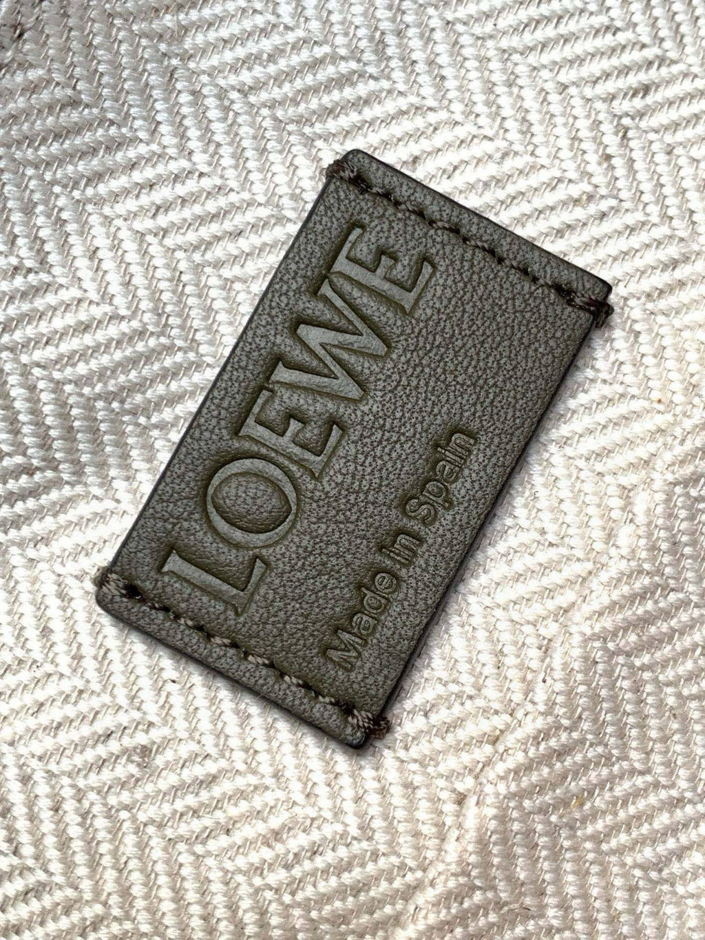 Loewe logo leather patch on fabric lining with text LOEWE