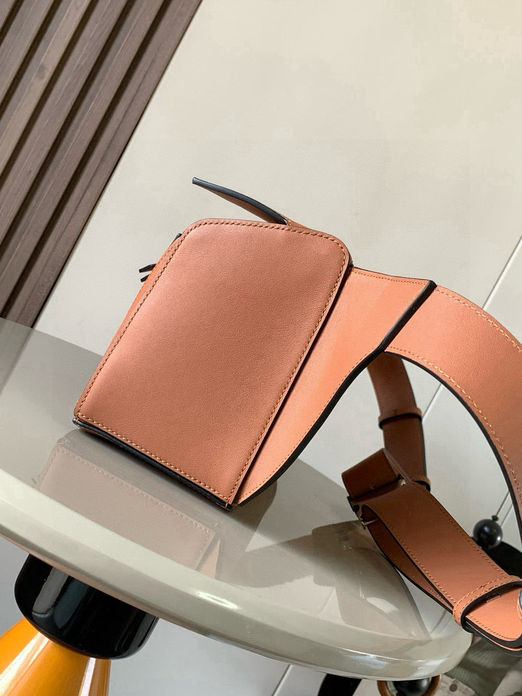 Loewe peach leather bag with front flap pocket, zip track detail, and shoulder strap