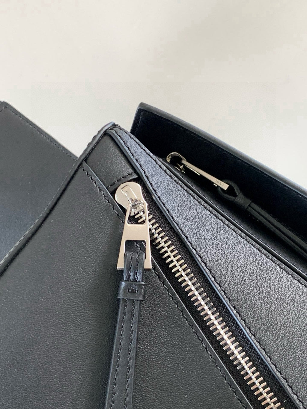 Loewe dark blue leather crossbody bag close-up of front zip and zipper pull