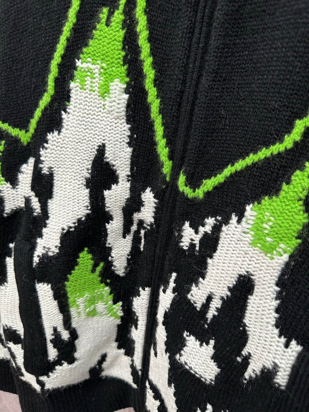 Gucci black knit sweater close-up of white figures with neon green outline