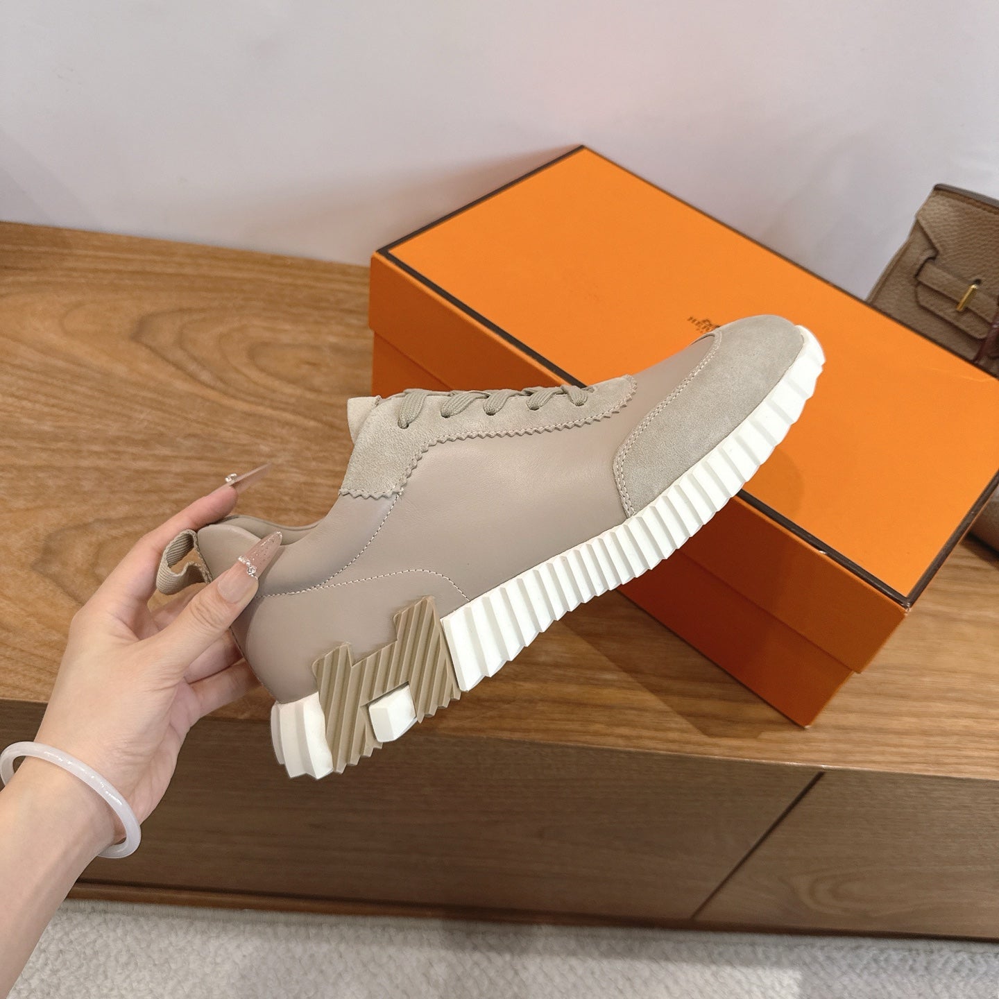 Beige sneaker with lace-up closure and thick white striped rubber sole