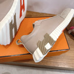 Beige sneaker side with ribbed white sole and laces, shown from below angle