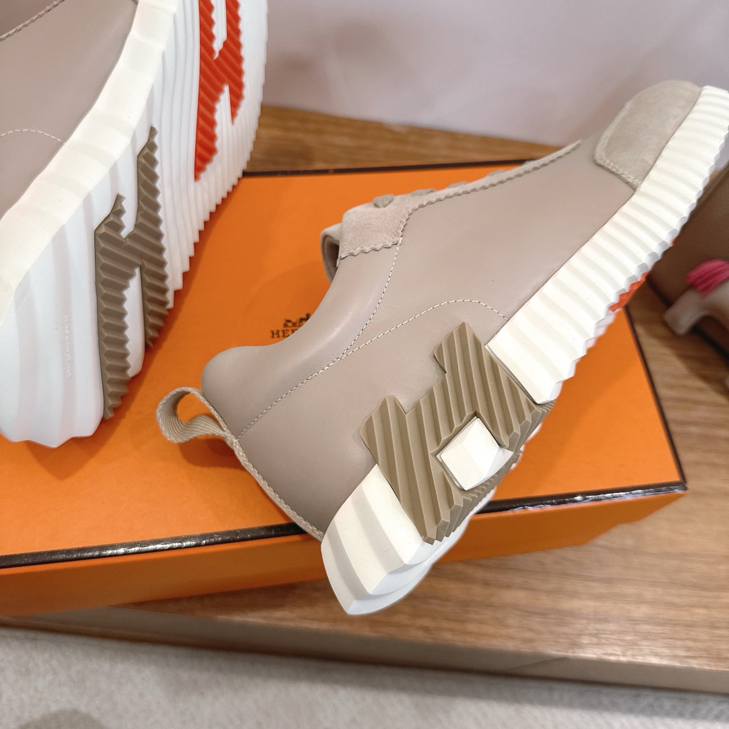 Beige sneaker side with ribbed white sole and laces, shown from below angle