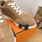 Tan suede sneaker close-up with white laces and ridged white sole with black detail