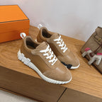 Tan sneakers with white laces, side panels, and chunky white ridged sole