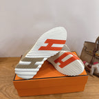 Beige sneaker outsole with striped tread and orange box base