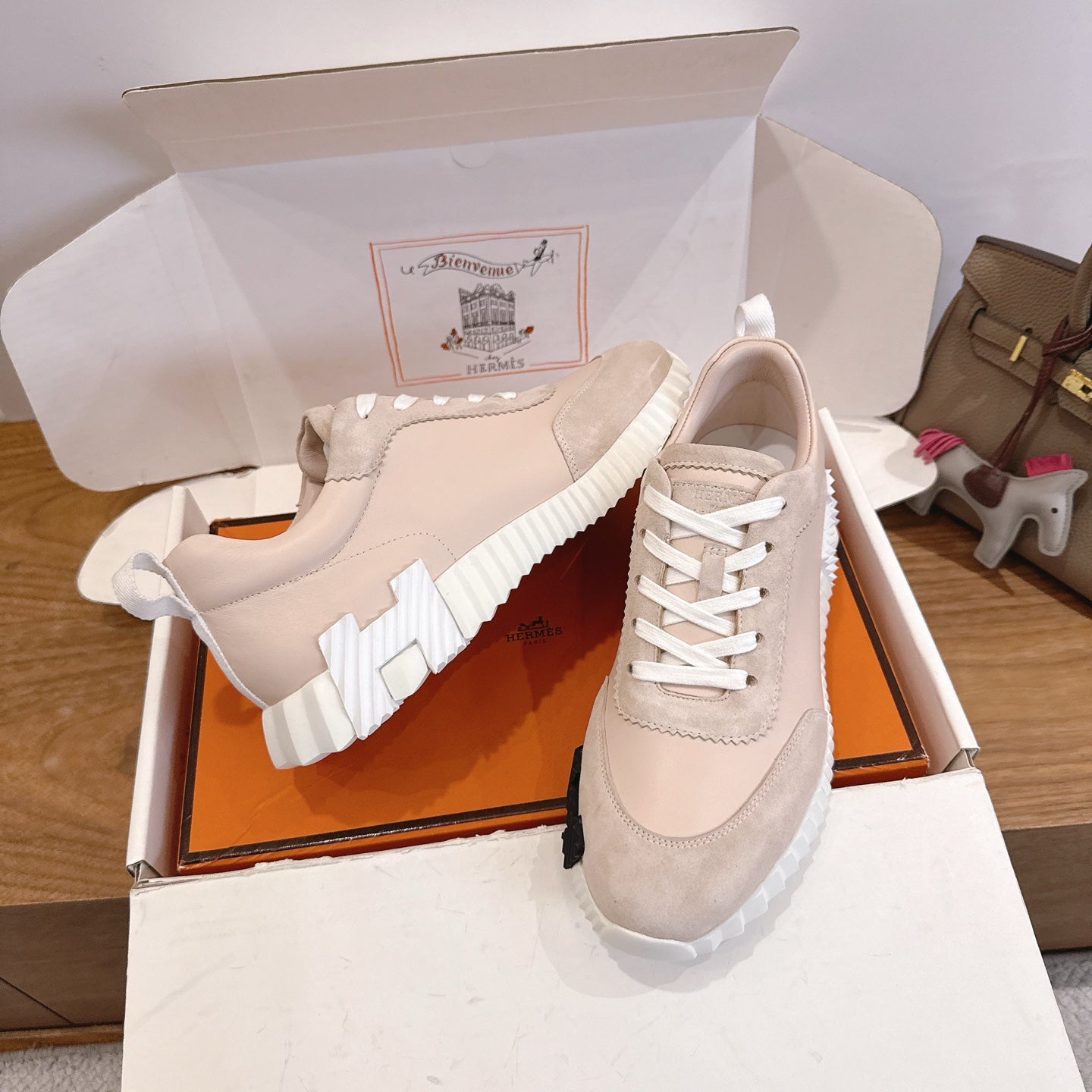 Unisex beige sneakers with white laces and thick white sole, angled view