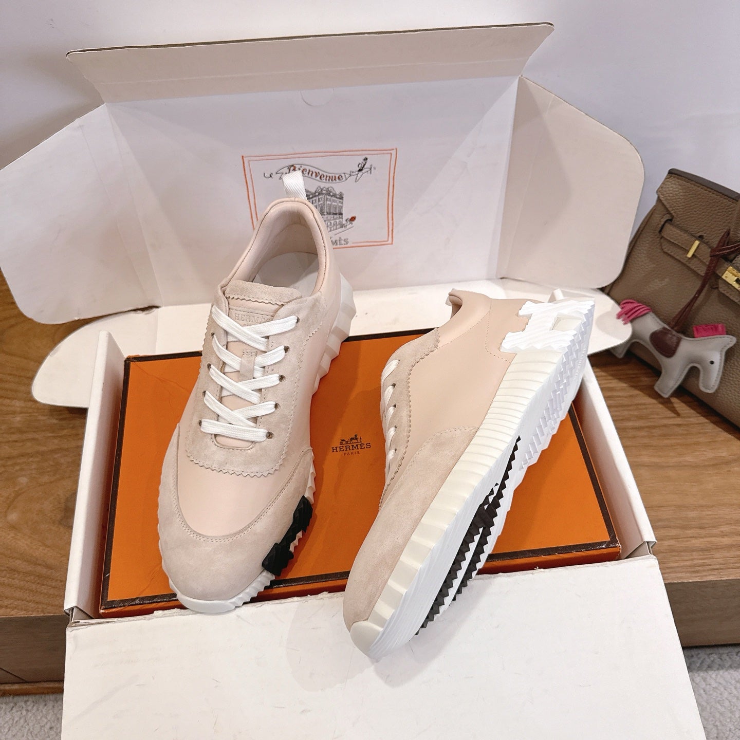 Unisex beige sneakers with white laces, side and front view on display